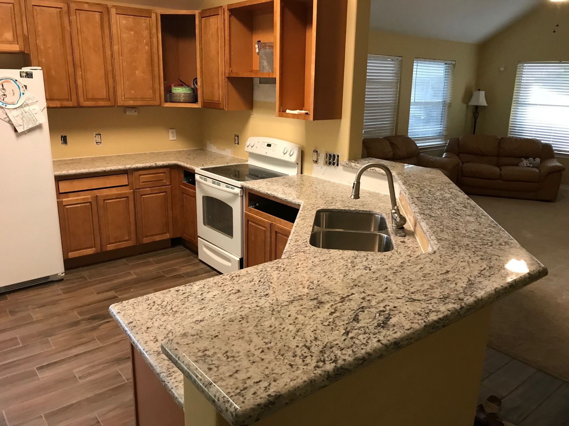 Kitchen with wood cabinets, granite countertops, and a white stove.