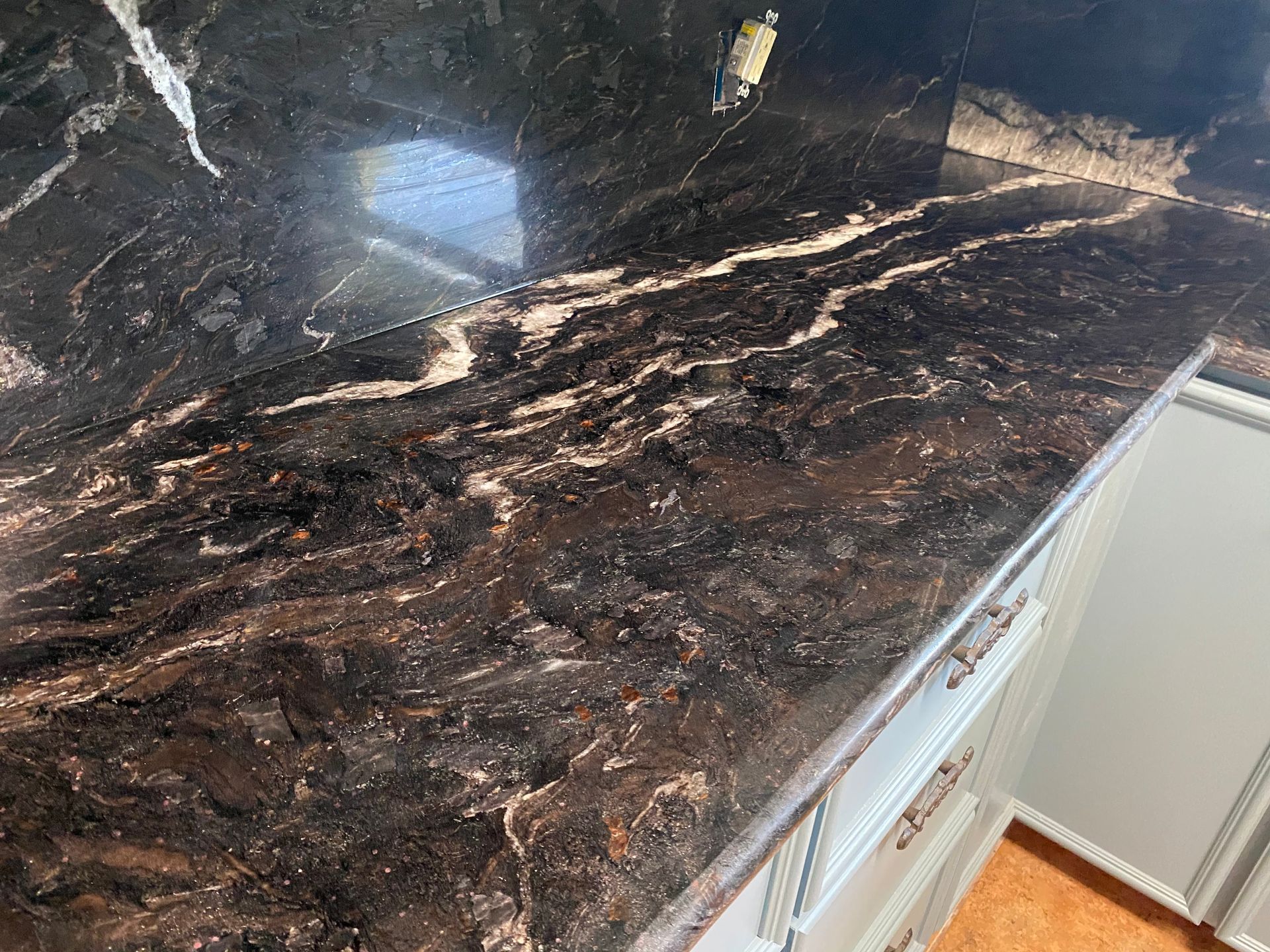 Dark granite countertop with white and gold veining.