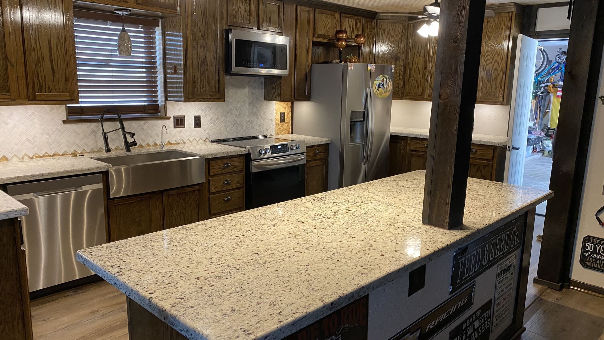 Kitchen with brown cabinets, stainless steel appliances, and a light-colored countertop with an island.