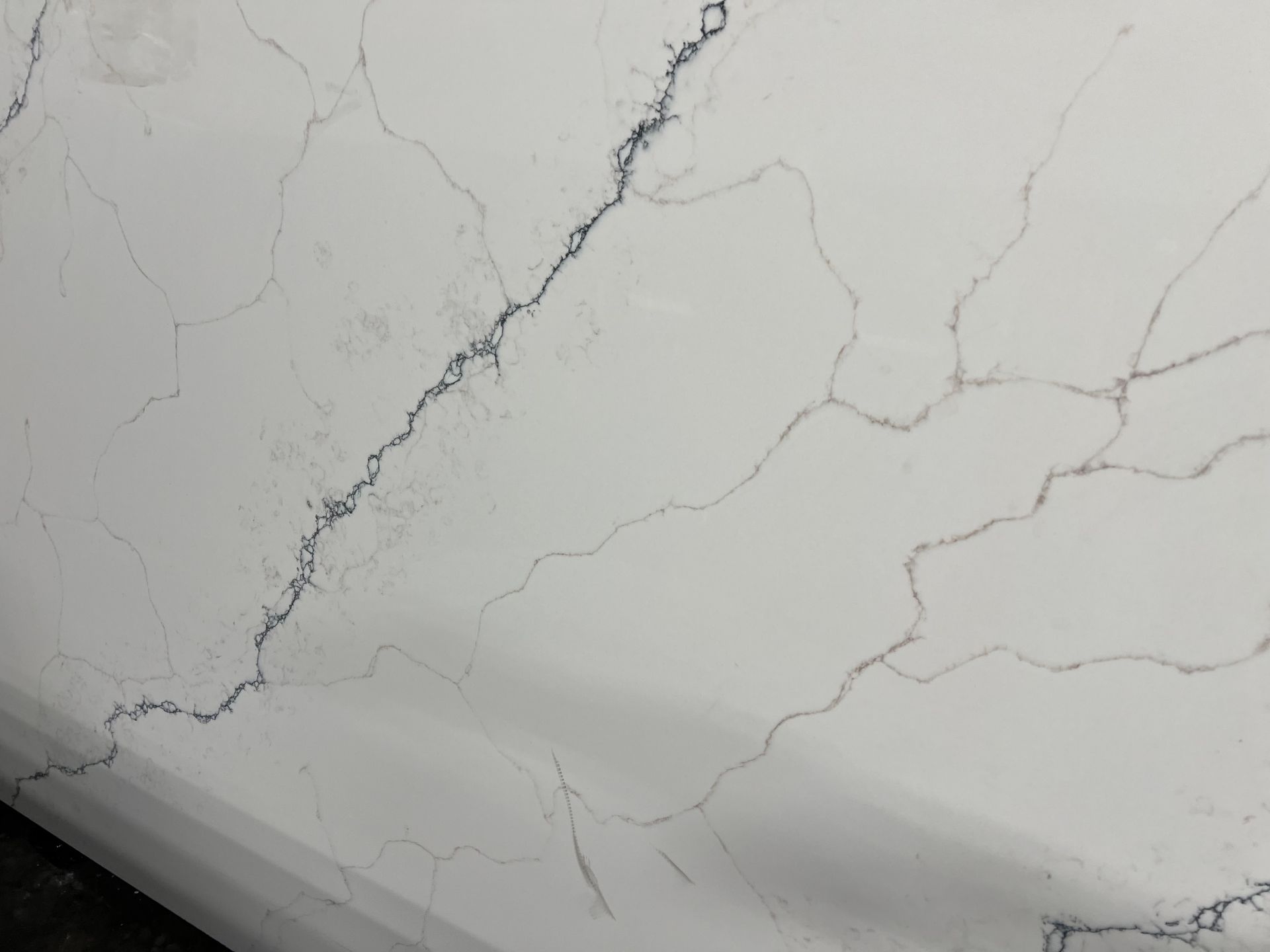 A close up of a white quartzite counter top with black veins.
