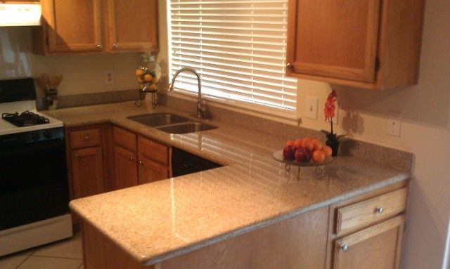 Kitchen with light brown cabinets, beige countertops, sink, window with blinds, and a stove.