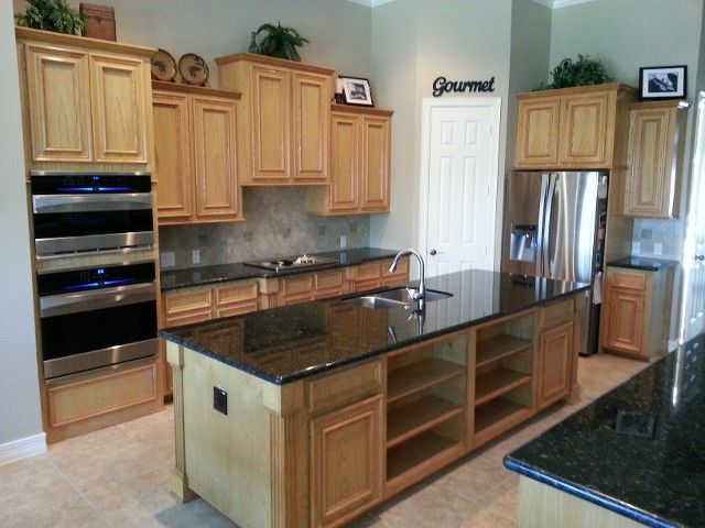 Kitchen with light wood cabinets, granite countertops, and a large island.