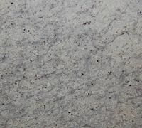 Close-up of a white granite countertop with gray and black speckles and veins.