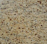 Close-up of granite surface with beige and brown swirls and speckled dark spots.