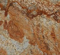 Swirling textured granite with red-brown and cream colors.