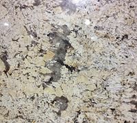 Close-up of a speckled granite countertop with beige, gray, and black patterns.