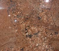 Close-up of a reddish-brown granite surface with a speckled pattern.