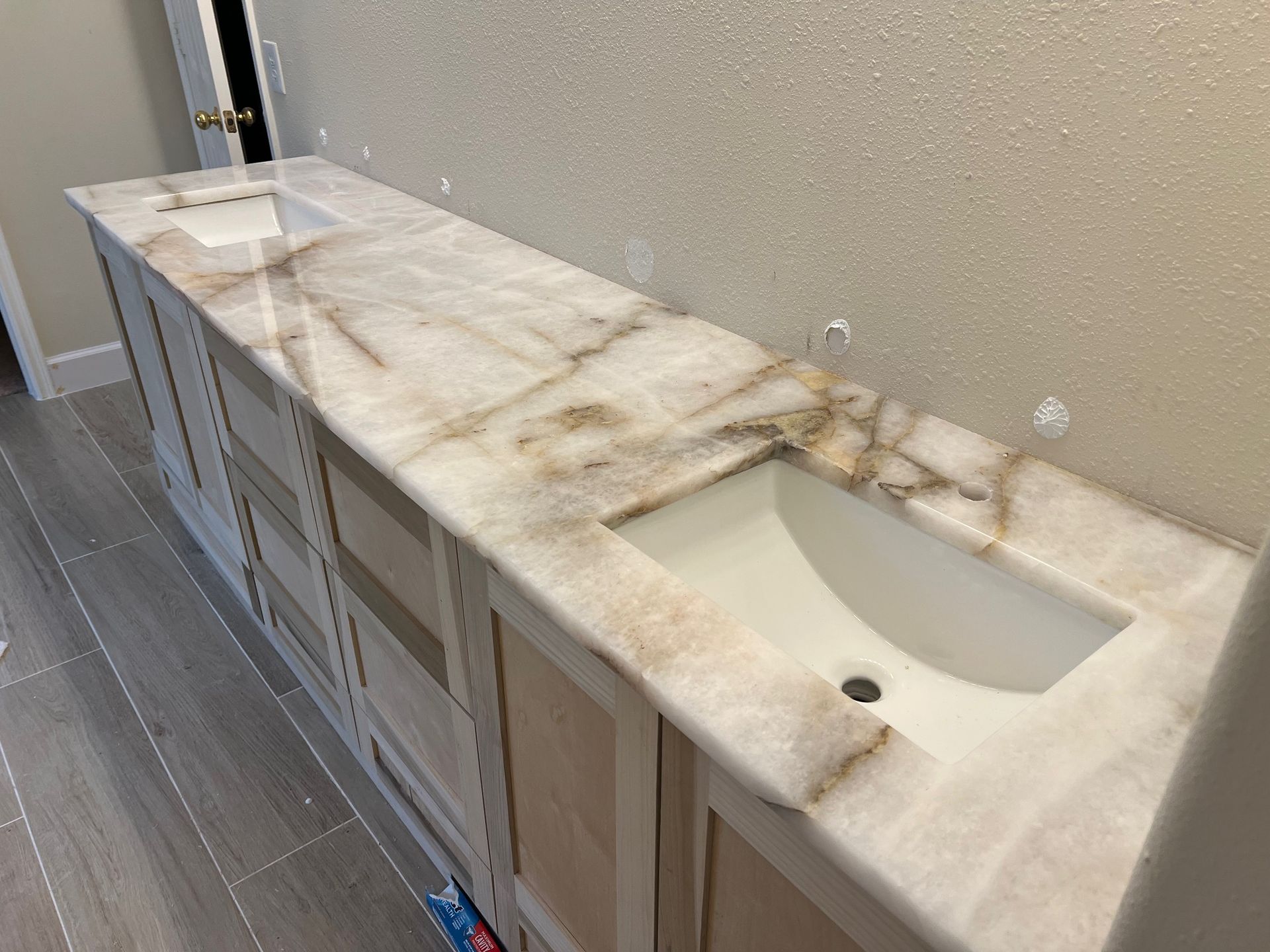 Bathroom vanity with marble countertop and two sinks, installed.