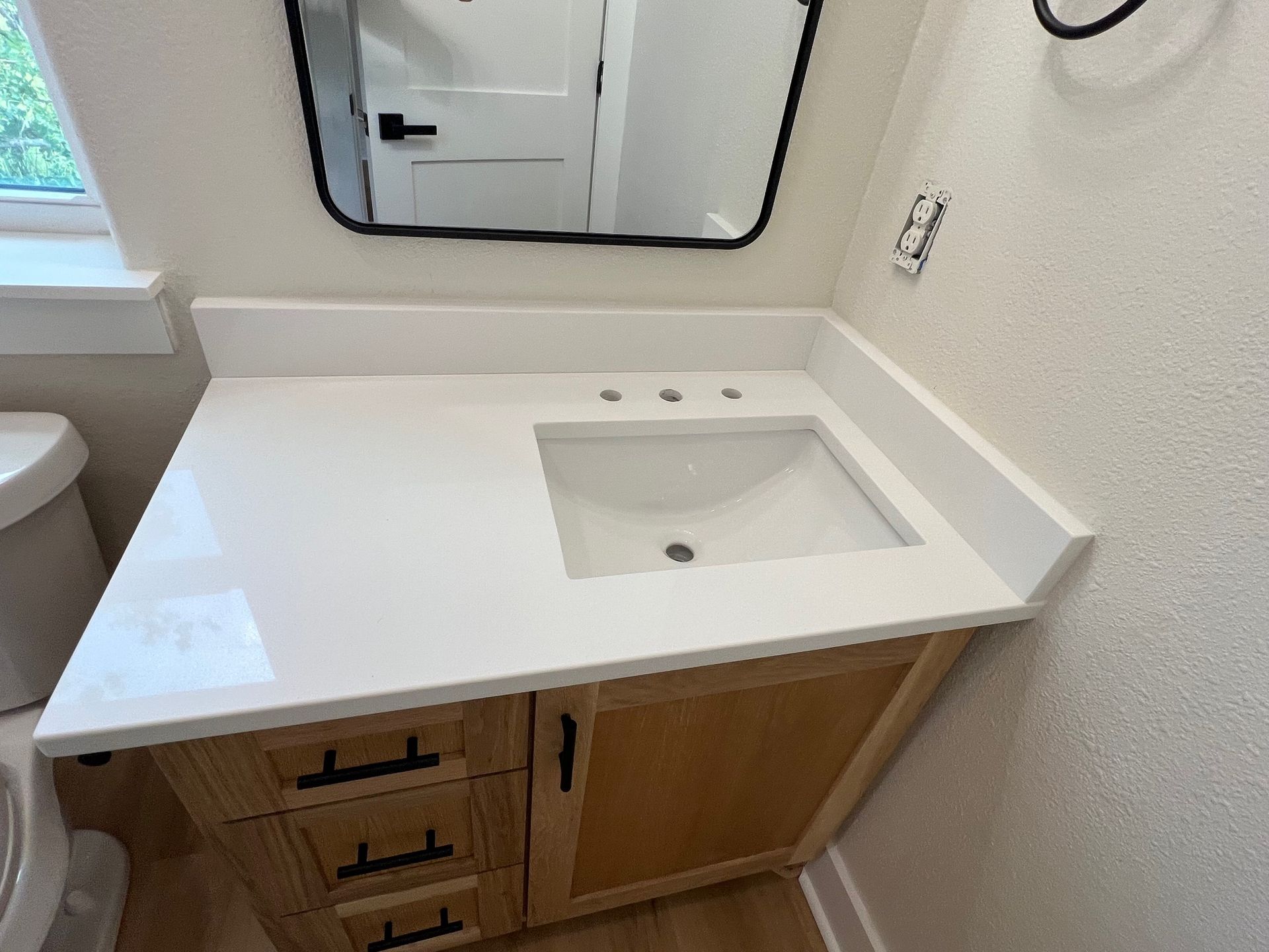 A bathroom with a sink , toilet and mirror.