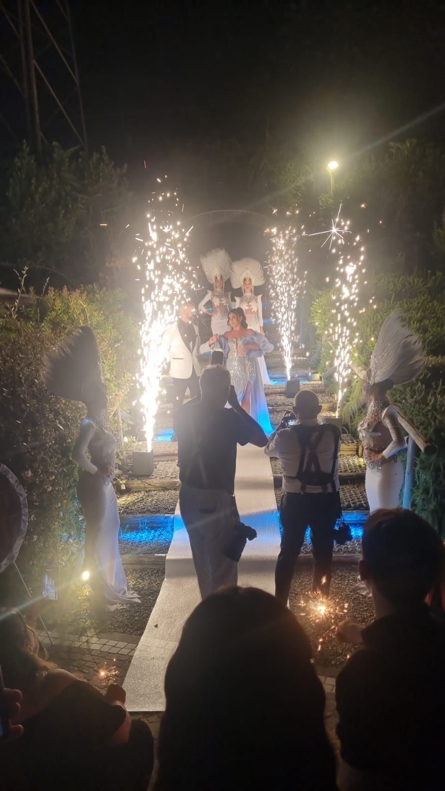 Di notte, persone in costume scendono le scale con le stelle filanti.