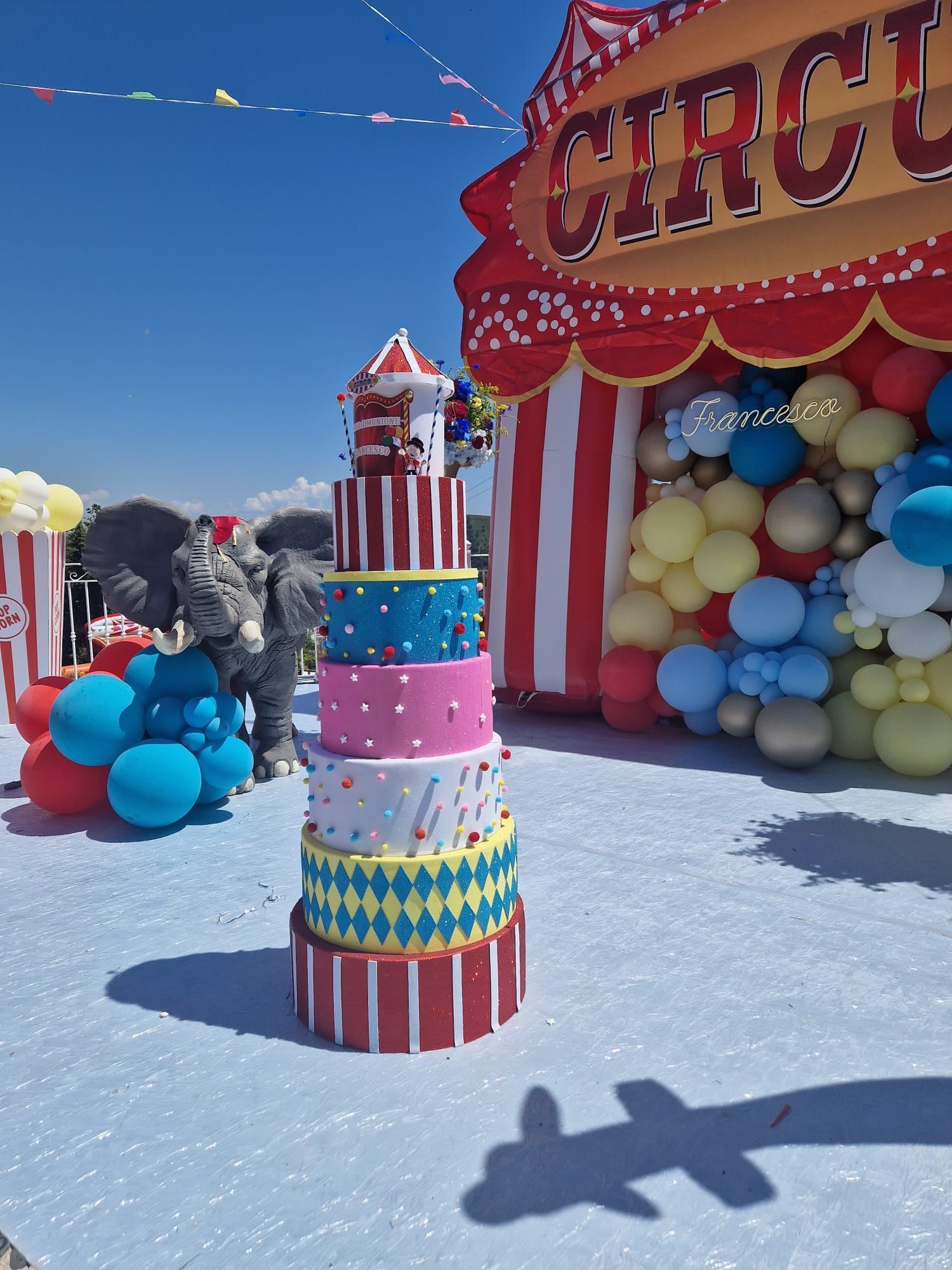 Festa a tema circense con torta a più piani, tendone da circo all'ingresso e decorazioni con palloncini.