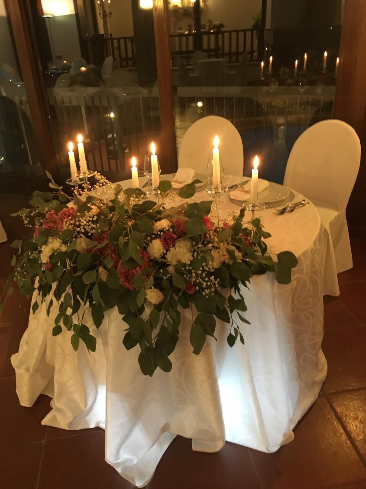 Romantica apparecchiata con candele e fiori.