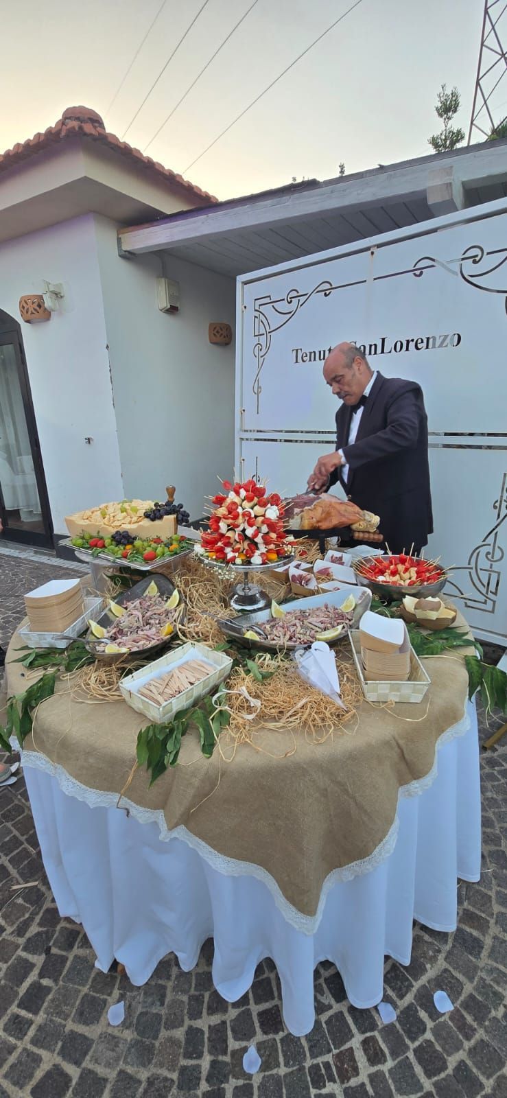 Un tavolo apparecchiato con un uomo che taglia la carne.