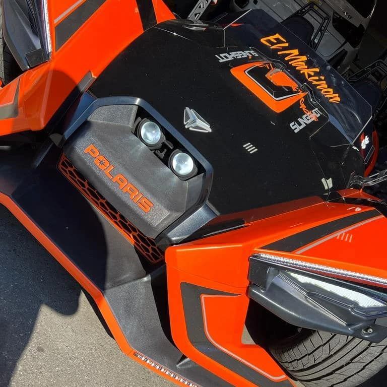 Orange and black Polaris Slingshot three-wheeled vehicle with 