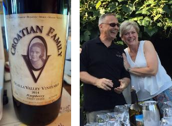 A man and woman are standing next to a bottle of croatian family wine.