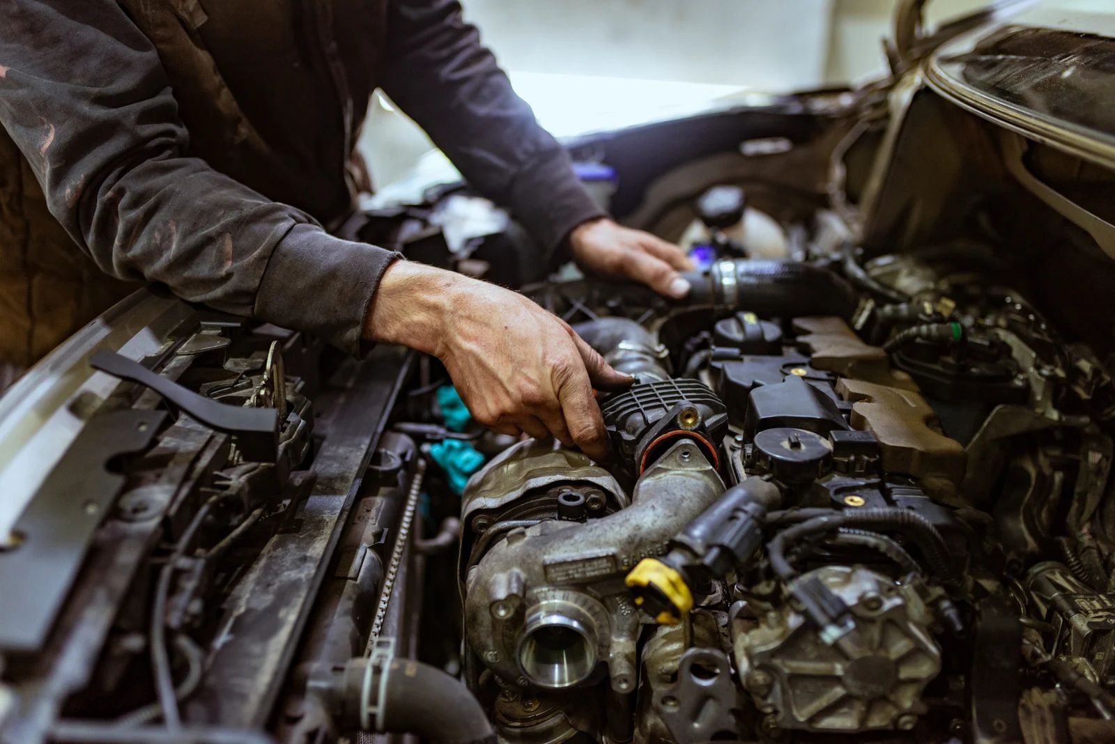 A man is working on the engine of a car.