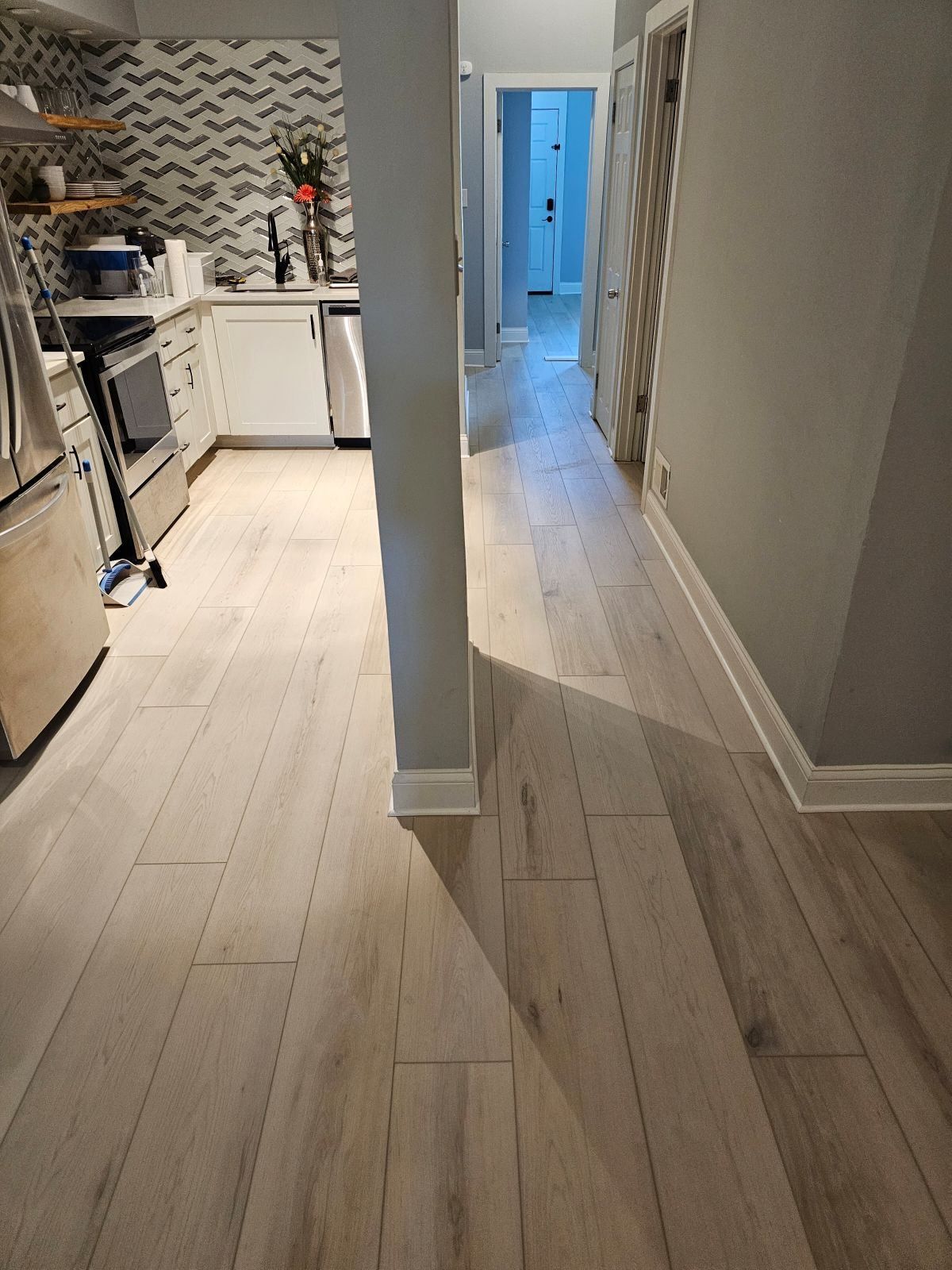 A kitchen with hardwood floors and stainless steel appliances.