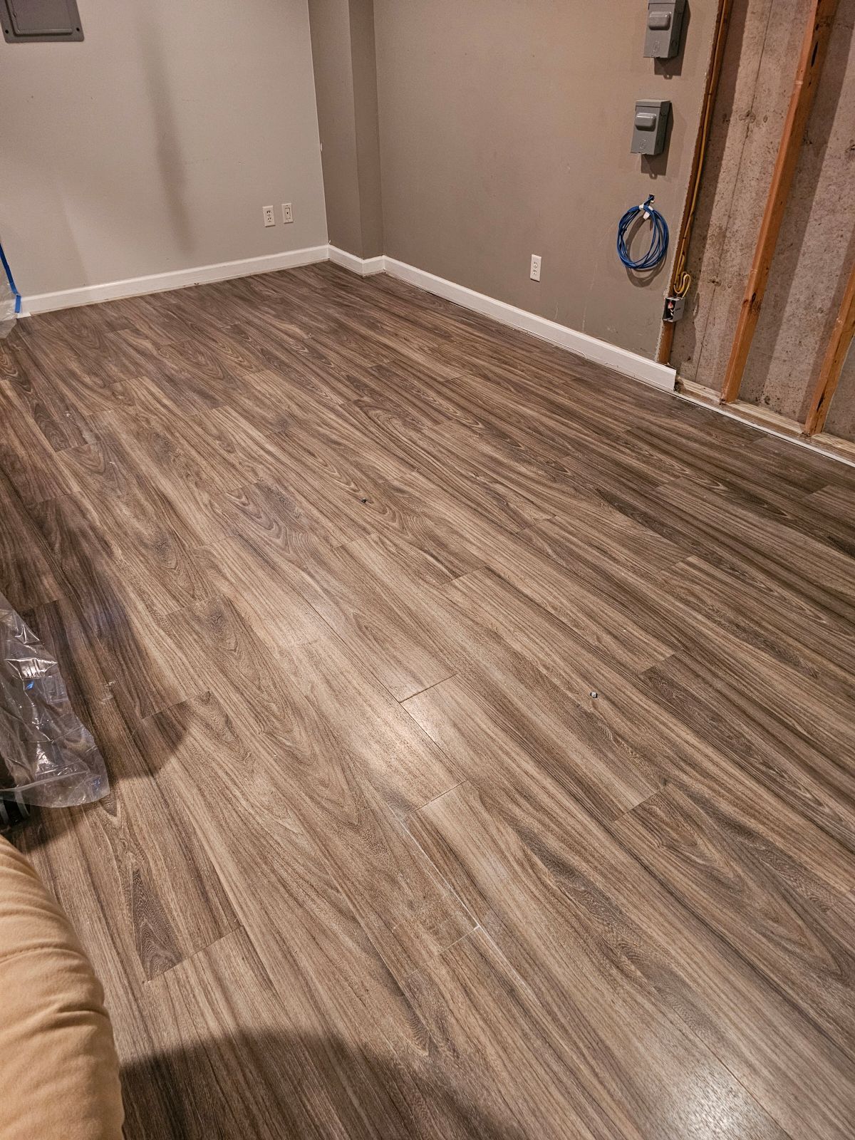 A room with a wooden floor and a couch in it.