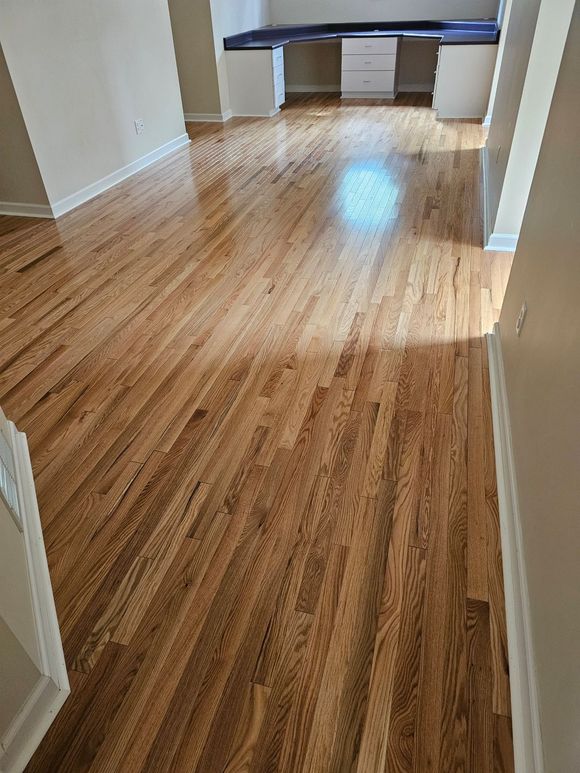 A living room with hardwood floors and a desk.