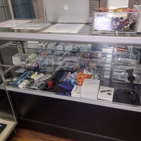 A glass display case filled with lots of items in a store.