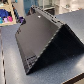 A black laptop is sitting on top of a blue table.