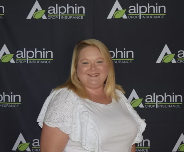 Woman smiling in front of a black backdrop with the 