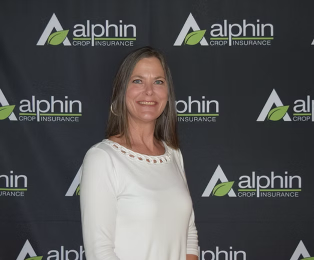 Woman smiling, posing in front of a black backdrop with the 