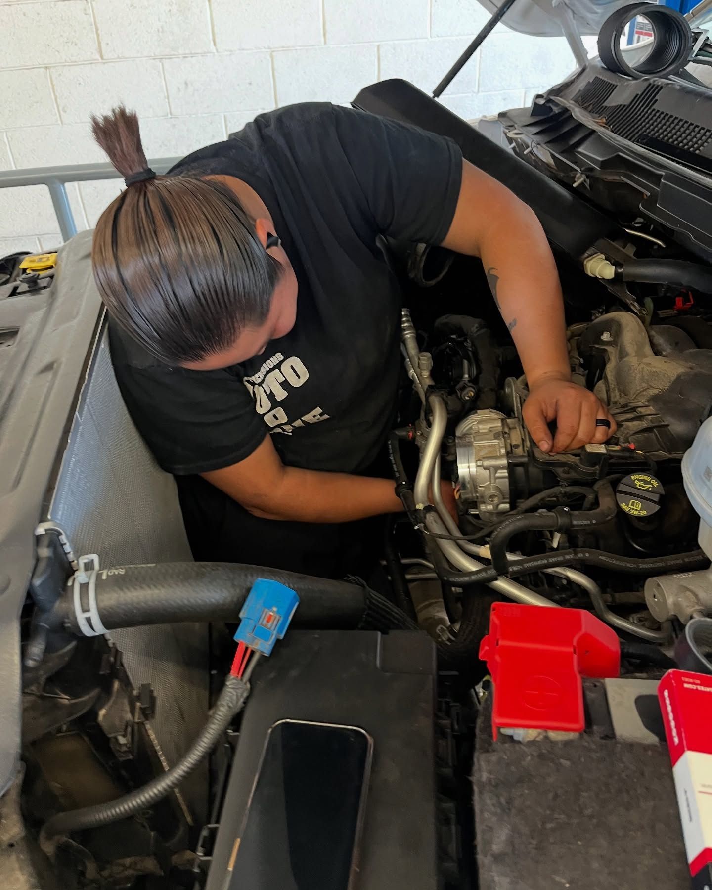 Technician Working Under Hood During Auto Diagnostics | New Dimensions Automotive