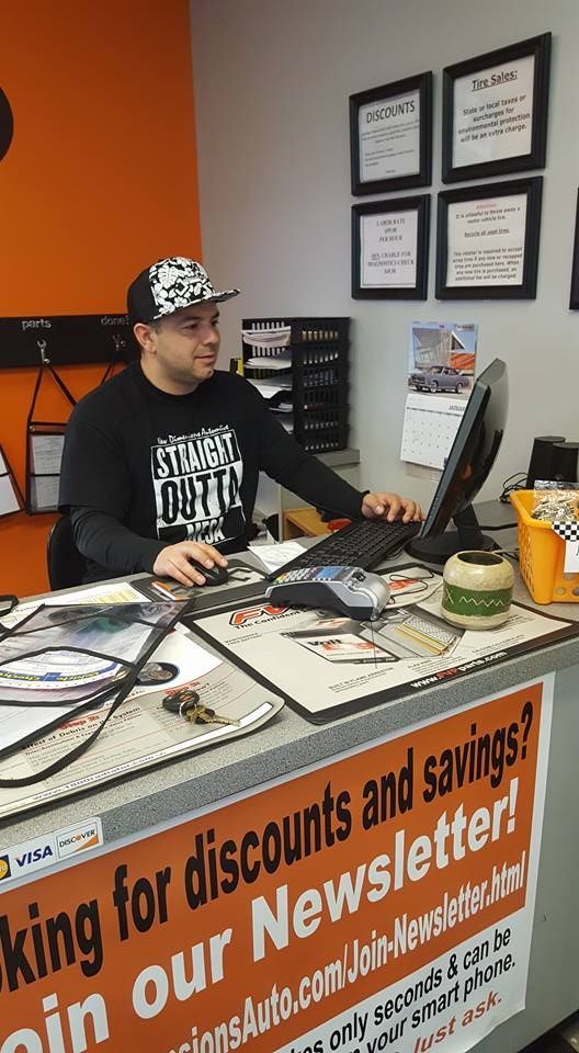 Team Member Standing At Front Counter In Auto Shop | New Dimensions Automotive