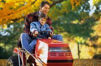 man and boy on lawn mower