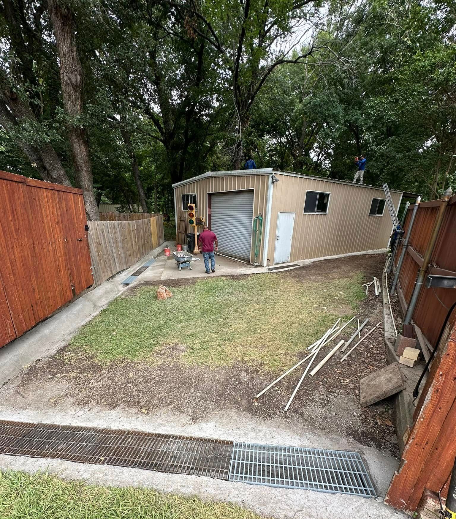 A group of people are working on a shed in a backyard.