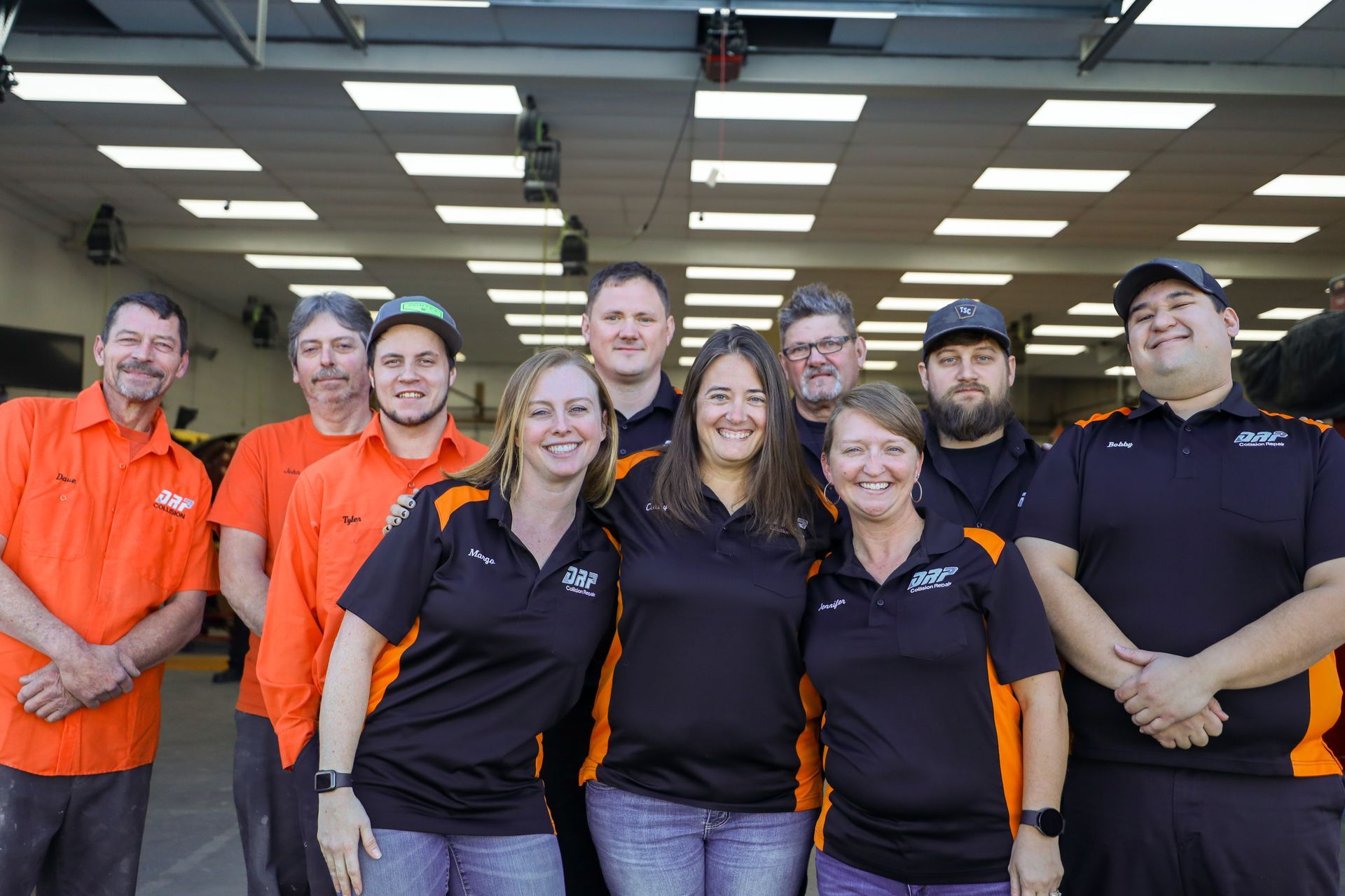 A group of people are posing for a picture in a garage.