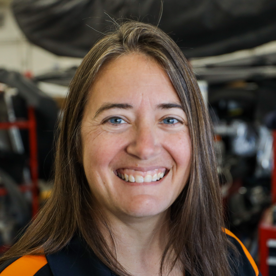 A woman with long hair is smiling for the camera