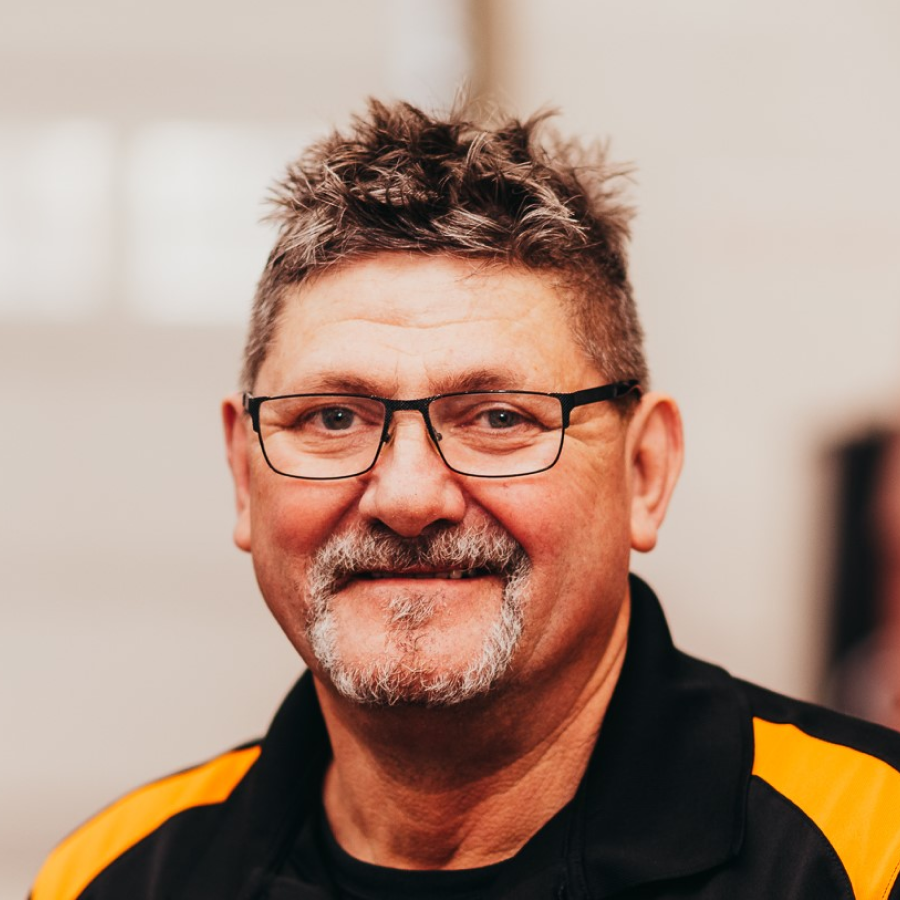 A man with glasses and a beard is smiling for the camera