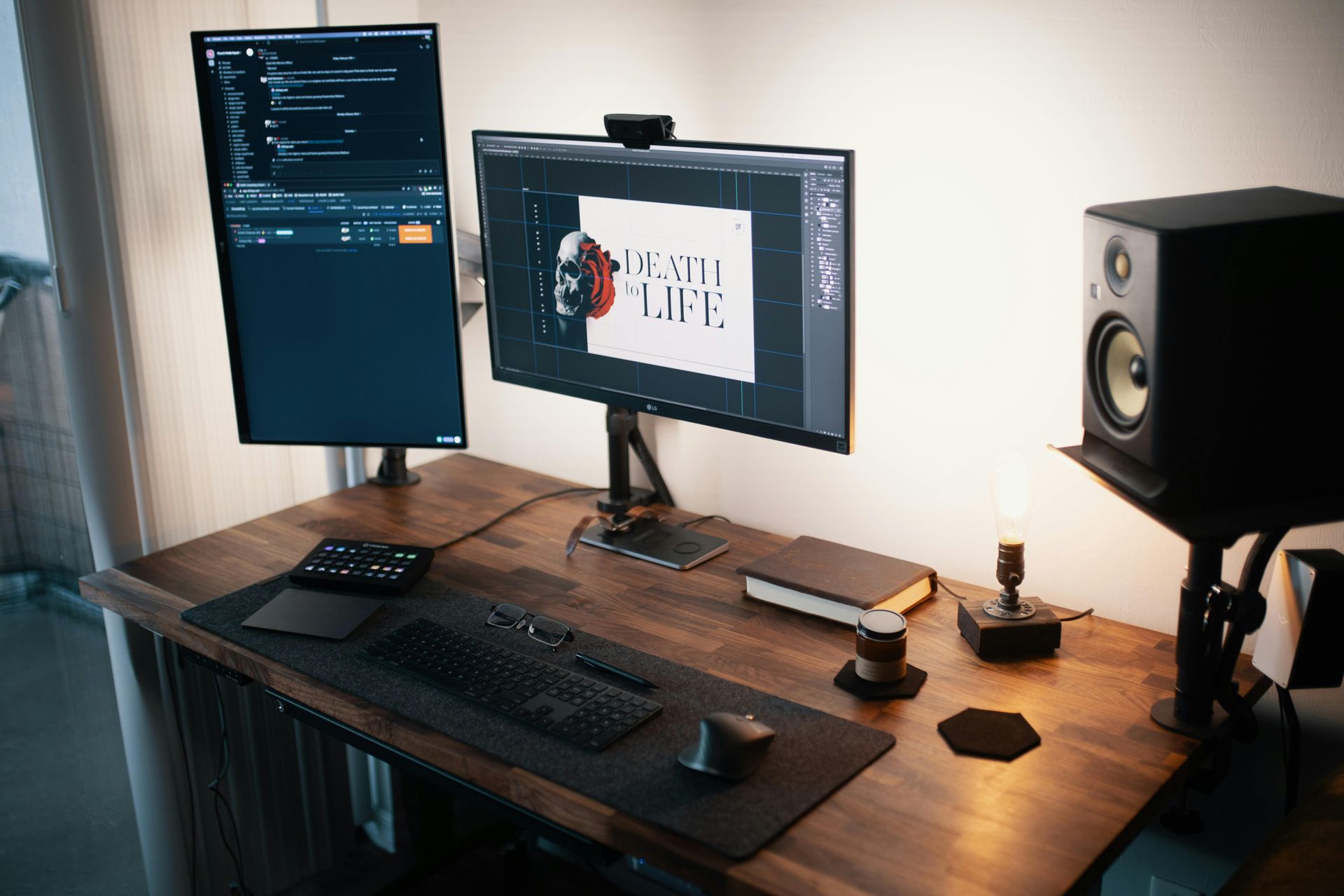 Wooden desk with two monitors, keyboard, mouse, speaker, and other desk accessories.