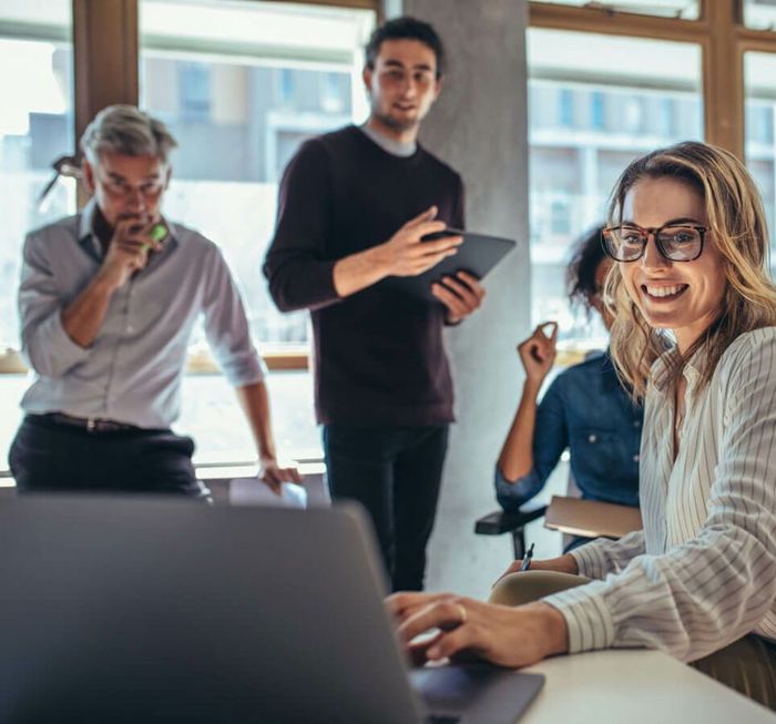 A group of people are sitting in front of a laptop computer showing expert SEO.