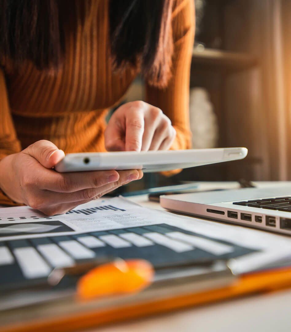 A woman is using a tablet computer to explore marketing strategy.