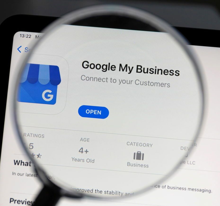 A magnifying glass is looking at the google my business app showing how we rank your Google Business Profile.