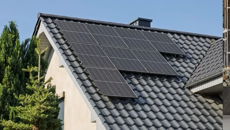 Solar panels on a gray tiled roof of a house. Blue sky and green trees in the background.