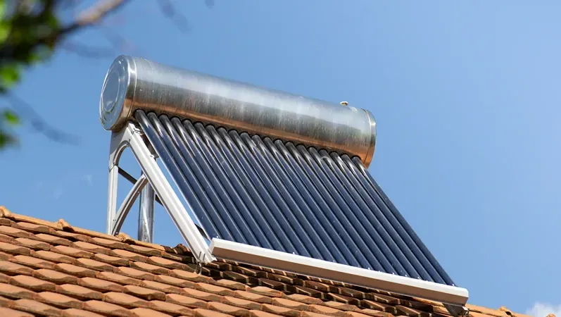 solar water heater on a roof top, solar water heating panel, blue sky in the background