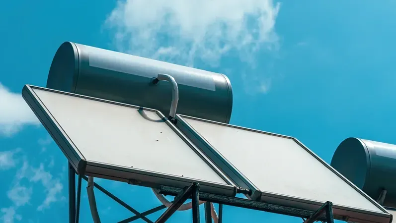 Close-up of rooftop solar water heater system under a clear blue sky. Clean energy and sustainable technology concept.Selective focus.