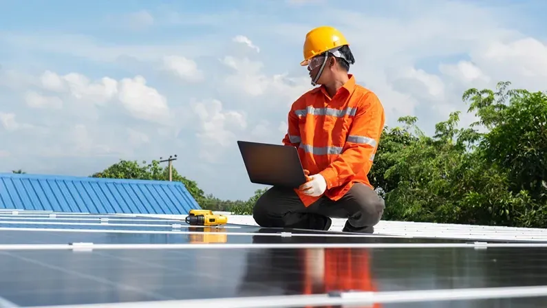 Asian technician Solar panels with a drill to install solar panels on the roof.