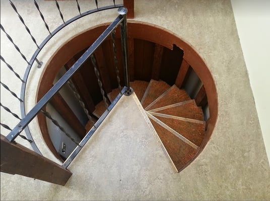 A spiral staircase with a wrought iron railing