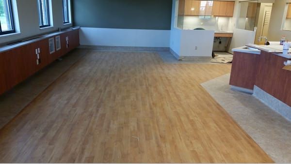 An empty room with a wooden floor and a counter