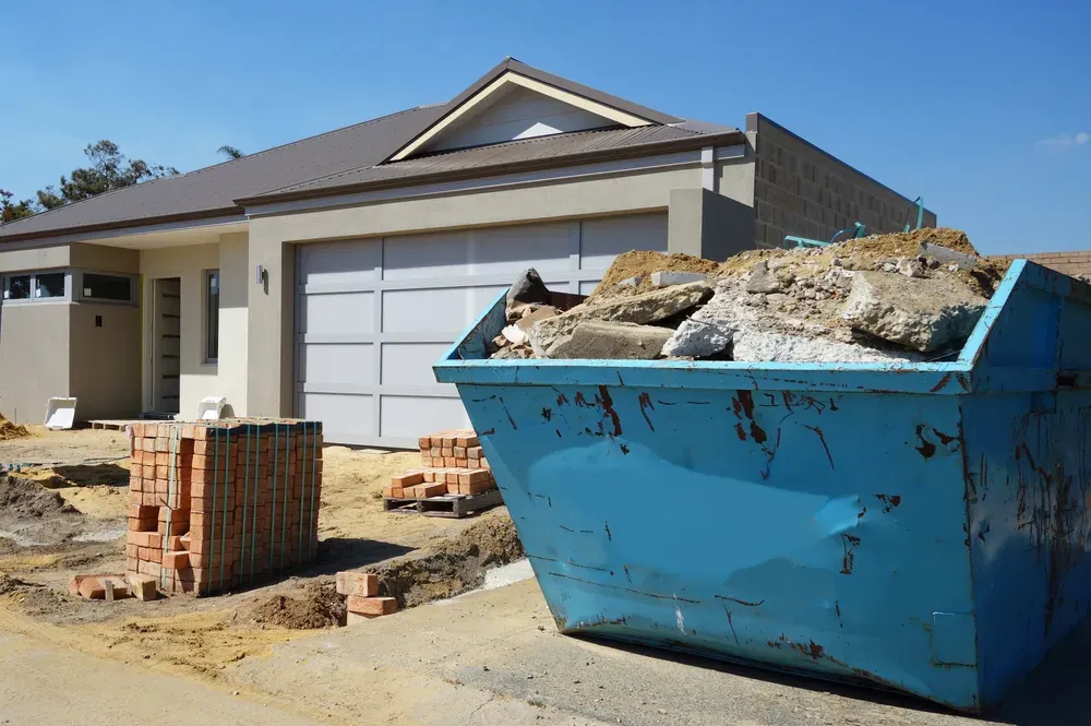 A House Construction Site With a Blue Skip Bin in Driveway  — Select Site Solutions in Kiama, NSW