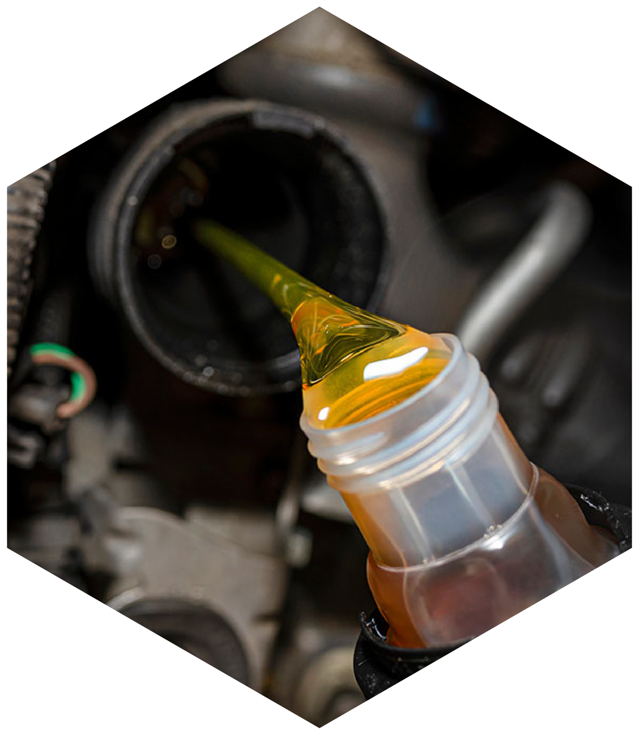 Yellow oil being poured into a car engine.