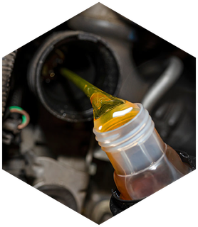 Yellow oil being poured into a car engine.