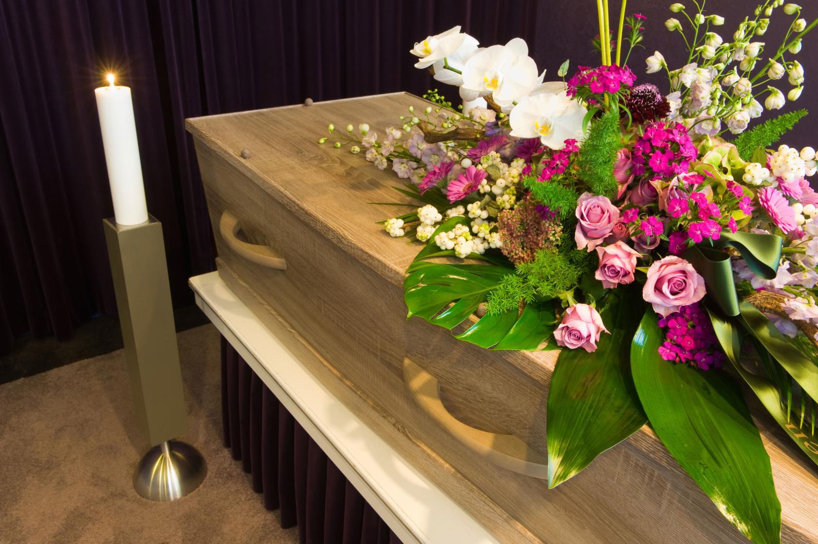 feretro con composizione floreale al di sopra