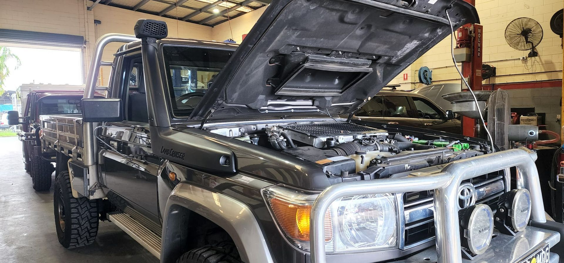 Dark Gray Toyota Truck With Hood Open in a Repair Shop — SVS Auto Repairs and Dyno Tuning in Bungalow, QLD
