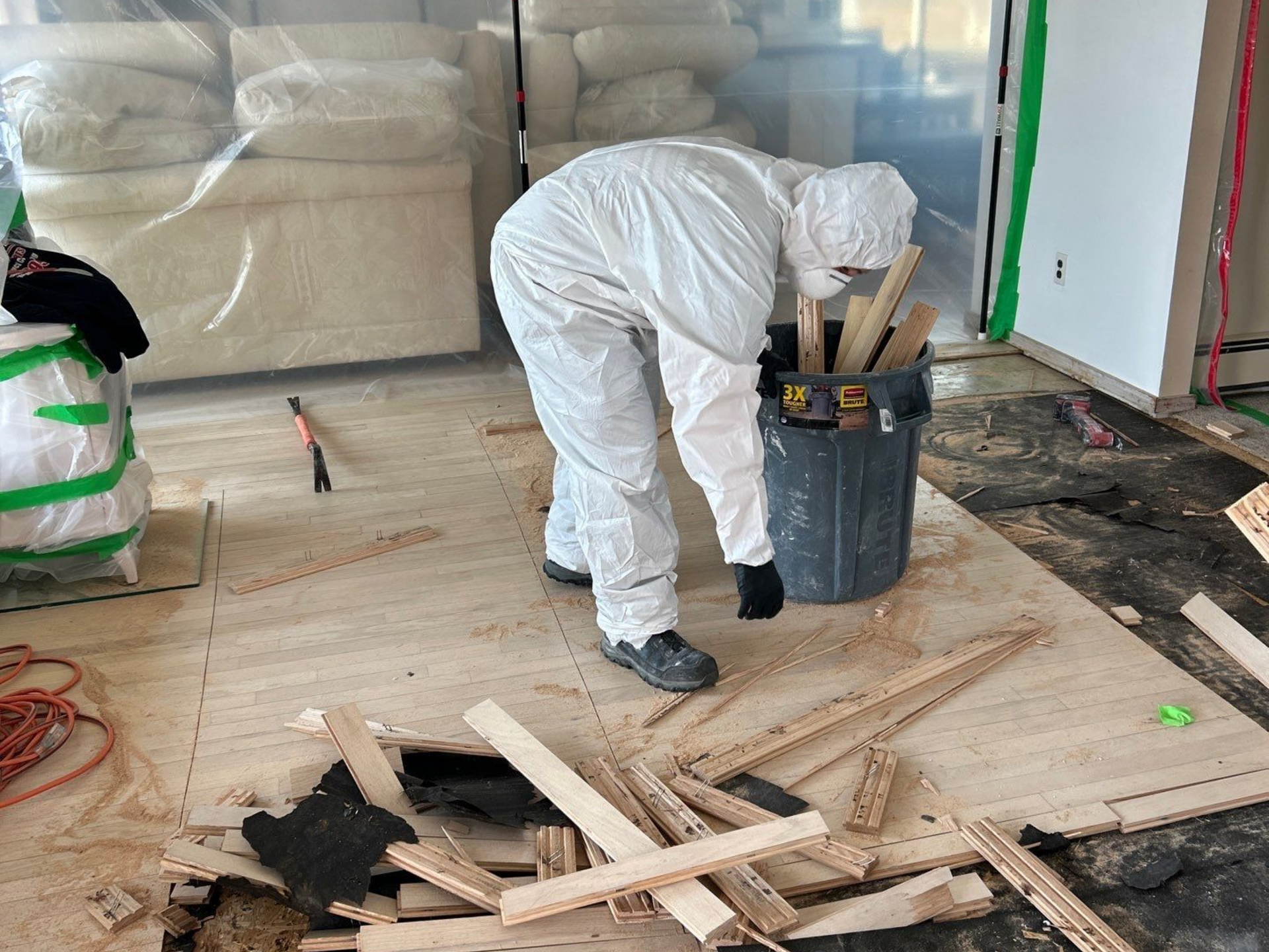 Unsalvageable hardwood flooring was removed from a home in Mastic Beach, NY due to water damage
